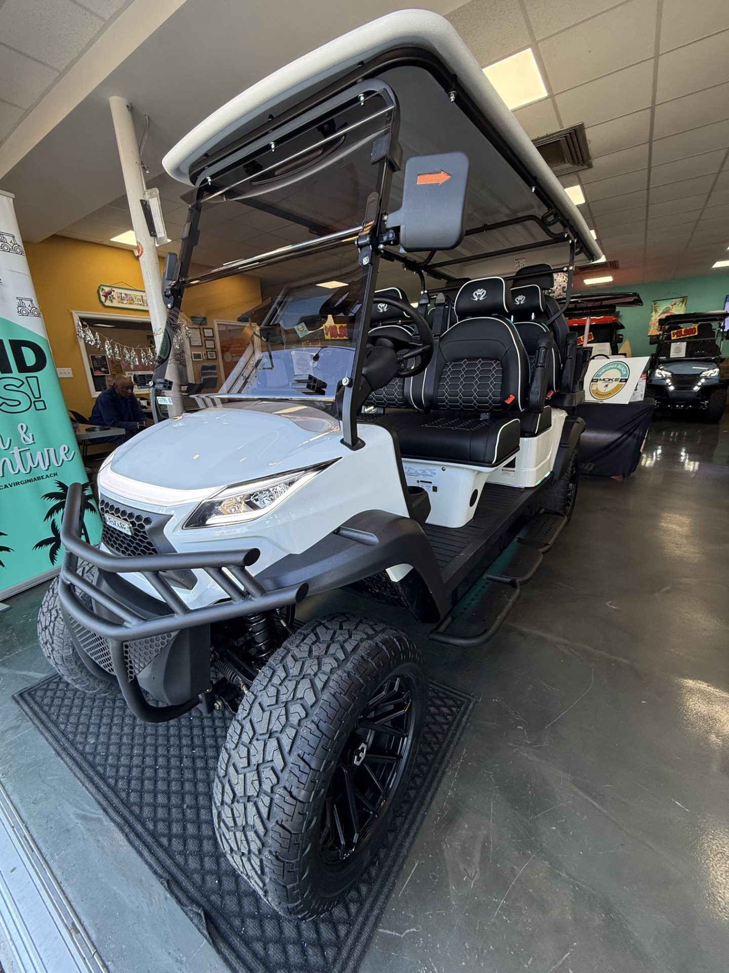 2026 Venom EV 6-Seater Strike white street legal cart with black hex-stitch seats and a lifted off-road stance in the Moke Virginia Beach showroom